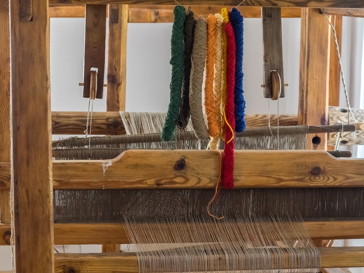  a wooden loom with colourful wool on it.