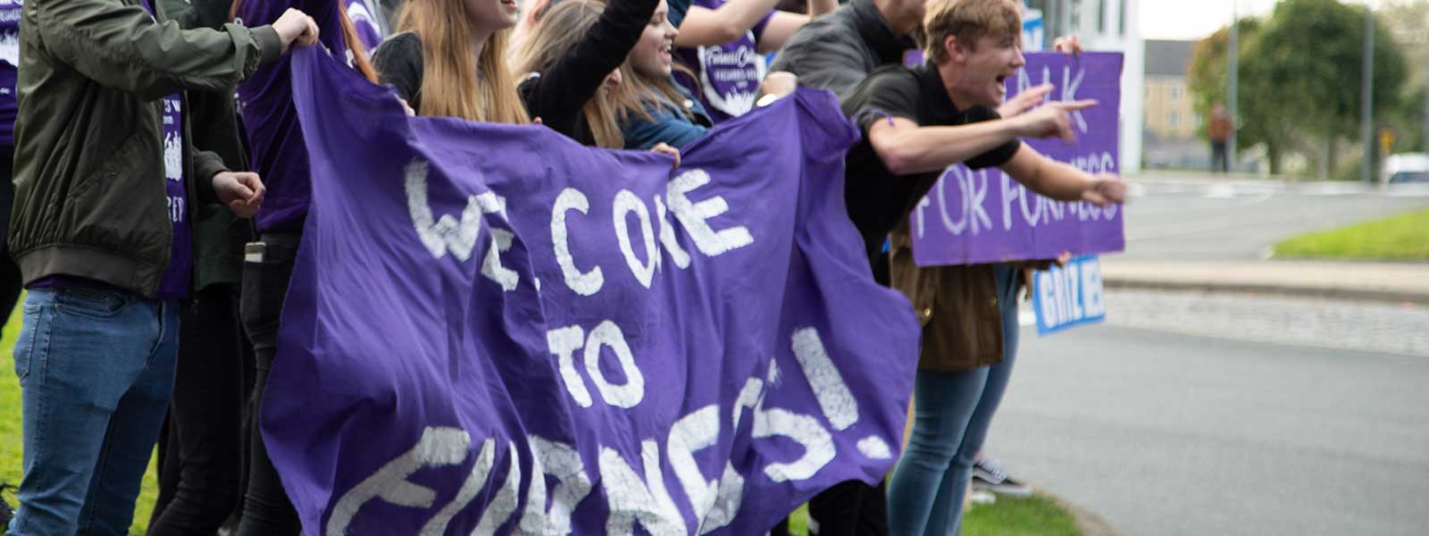 Students holding Furness welcome banners
