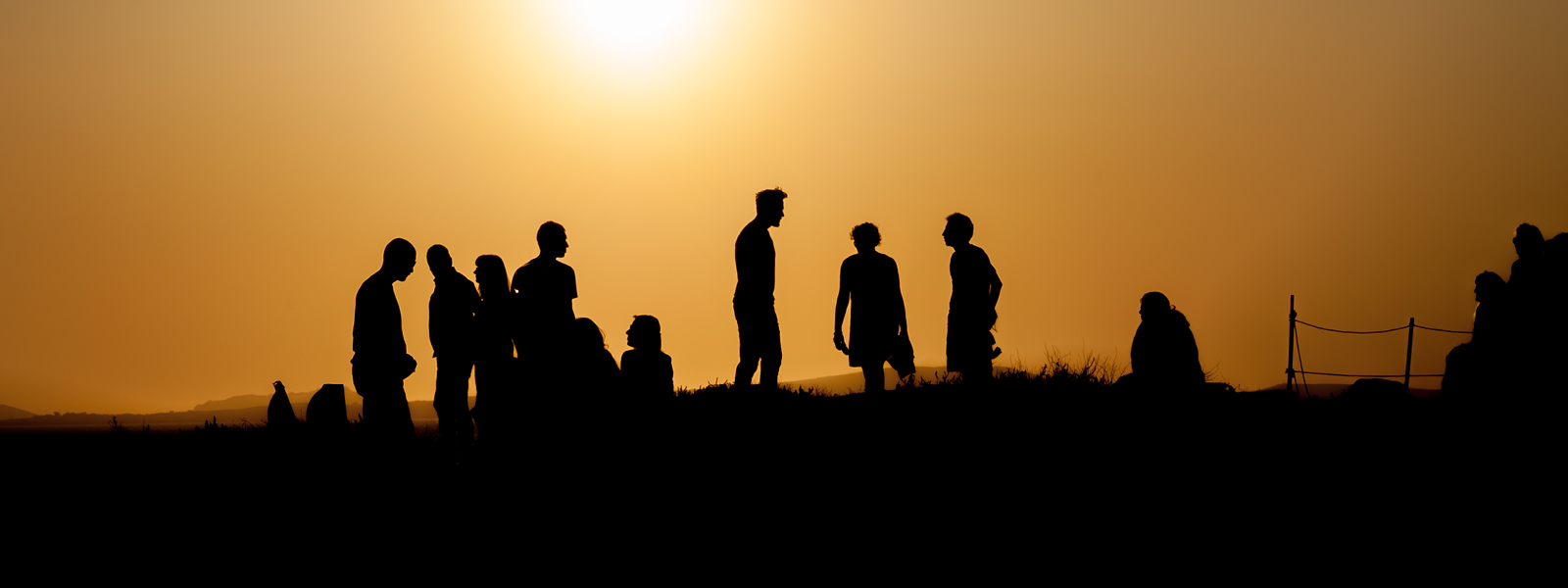 Silhouette of a group of people with a sunset in the background