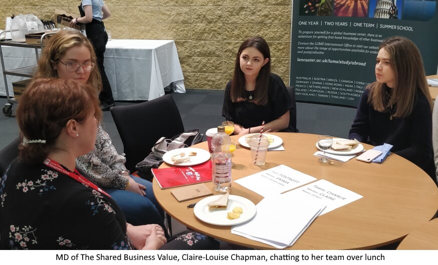 MD of The Shared Business Value, Claire-Louise Chapman, chatting to her team over lunch - four women sitting round table having a discussion, one with her back to viewer.